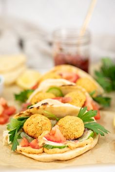 several pita breads with meat and vegetables on them sitting on a cutting board