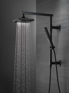 an overhead shower head with thermostaer and handset in black and white