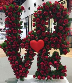 the letter r is made out of roses and has a red heart in front of it