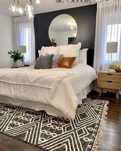 a white bed sitting in a bedroom on top of a wooden floor next to a window