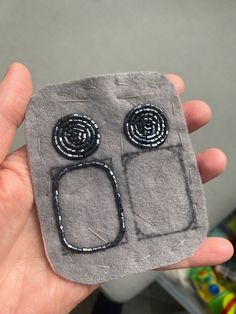 someone is holding up a small piece of felt with buttons on the front and sides