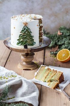 a white cake sitting on top of a wooden table next to a slice of cake