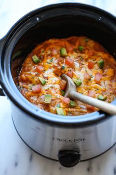 a crock pot filled with chili and cheese