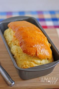 a loaf of bread sitting in a pan on top of a wooden cutting board