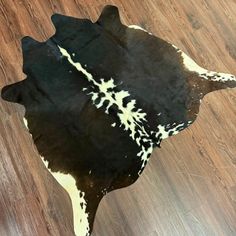 a black and white cowhide rug on a wooden floor