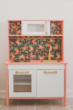 a pink and white cabinet with flowers on it