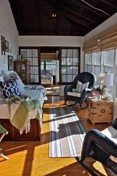 the sun shines through the windows into a bedroom with wood floors and white walls