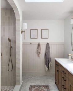 a bathroom with two sinks, a shower and a rug on the floor in front of it