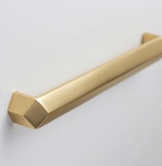 a gold handle on a white wall