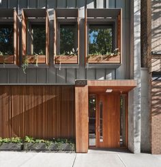 an entrance to a building with wooden slats on the side and windows above it