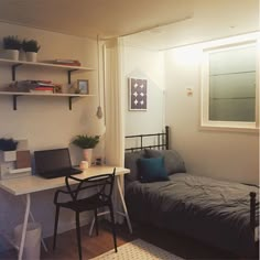 a small bedroom with a bed, desk and laptop computer on it's side