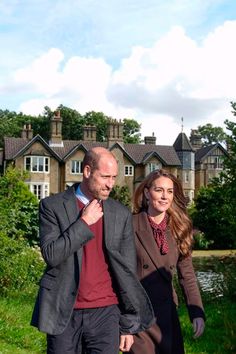 a man and woman walking in front of a house