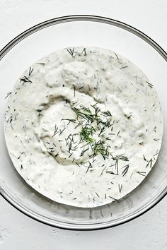 a bowl filled with ranch dressing on top of a table