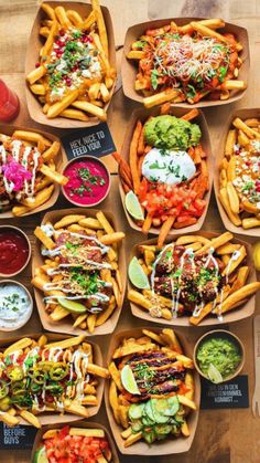 many different types of food on trays with drinks and condiments around them