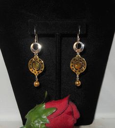 "Artisan long dangle earrings in both sterling silver and brass. The earrings start with a silver open center disk. Dangling below that is a brass disk with cutouts. Dangling at the bottom is a brass bead. Boho, big bold look, statement earrings. Hallmarks - The sterling disk is marked \"925 LT Indonesia and the brass disk is marked \"BRASS\". Ear wires were acid tested to be sterling silver. Measurements - About 2 3/4\" long by about 3/4\" wide. Condition - Very good. Comes gift wrapped in a sm Artisan Earrings, Long Dangle Earrings, Earrings Long, Earrings Statement, American Jewelry, Long Earrings, Ear Wires, Statement Earrings, Vintage Collection