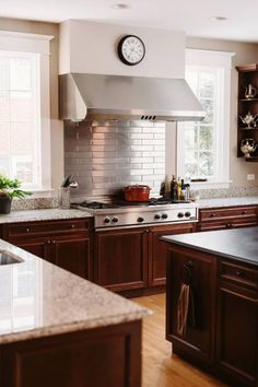 a kitchen with wooden cabinets and a clock on the wall above the stove top oven