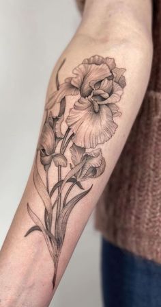 a woman's arm with a flower tattoo on it