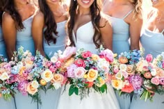 a group of women standing next to each other with bouquets in front of them