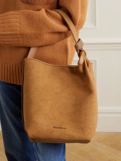 JW Anderson's latest 'JWA Corner' bag is made from soft brown canvas, which enhances the slouchy shape and relaxed look. It's topped with a matching suede handle, knotted around the designer's iconic oversized chain link, and has plenty of room inside for your phone, purse and makeup compact. Hobo Shoulder Bag With Suede Lining, Everyday Hobo Bag With Suede Lining, Brown Bag With Suede Lining, Chic Brown Shoulder Bag With Suede Lining, Brown Work Bag With Dust Bag Included, Chic Brown Bag With Suede Lining, The Row Bag, Makeup Compact, Denim Flats