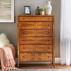 a wooden dresser sitting next to a window