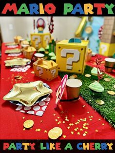 a party table is set up with gold plates and cupcakes for mario birthday