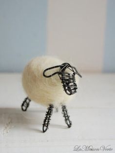 a small sheep made out of wire and yarn