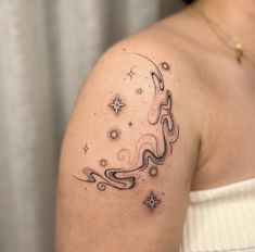 a woman with a tattoo on her shoulder has a snake and stars in the sky