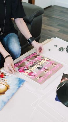 a person sitting at a table with some records on it and an album in front of them