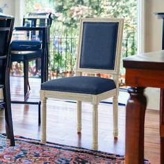 a dining room table and chairs in front of a window with an area rug on the floor