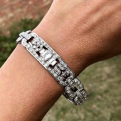 a close up of a person's hand wearing a bracelet with diamonds on it