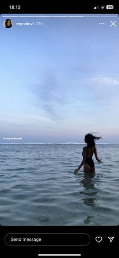 a woman in the water with her hair blowing back and looking up at the sky