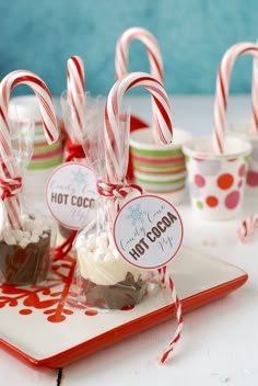 candy canes and hot cocoa on a plate with paper cupcakes in the background