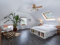 an attic bedroom with white walls and wood floors