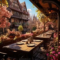 an outdoor dining area with tables and chairs in front of flowers on the outside wall