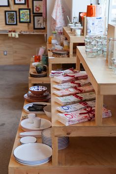 there are many plates and bowls on the shelves in this store that is filled with dishes