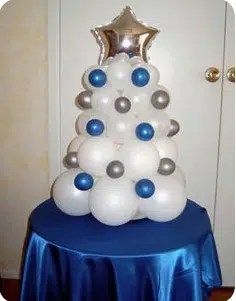 a christmas tree made out of balloons on top of a blue and white table cloth