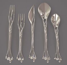 four forks, two spoons and one knife are arranged in the shape of flowers