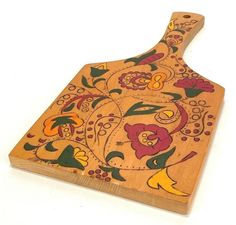 a wooden cutting board with colorful designs on it's sides and an animal design on the bottom