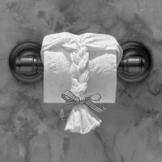 a white napkin wrapped in a knot on a bathroom door handle