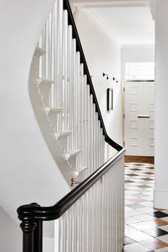 a white staircase with black handrails and tiled floor