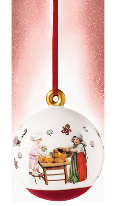 a christmas ornament hanging from a red ribbon with two women at a table