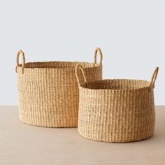 two woven baskets sitting on top of a wooden table