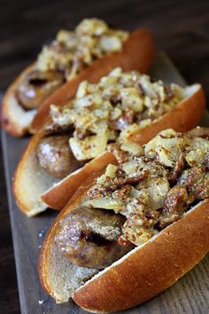 three hot dogs with toppings sitting on a tray