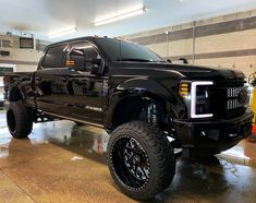 a large black truck parked in a garage