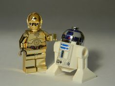 two lego star wars characters standing next to each other