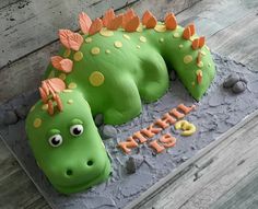 a cake shaped like a green dinosaur laying down