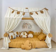 a child's bed with stuffed animals on the bottom and canopy over it,