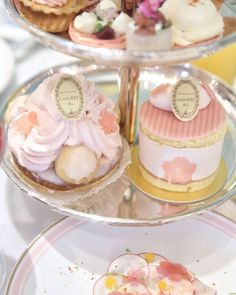 three tiered trays filled with different types of cakes and pastries on top of each other