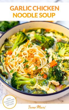 a bowl of chicken noodle soup with broccoli and carrots in it