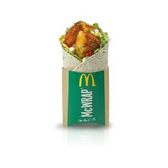 a wrap filled with meat and vegetables sitting on top of a white table next to a mcdonald's sign